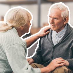 Ehefrau tröstet demenzkranken Senior auf dem Sofa – Betreuung in Pflegeeinrichtungen für Demenzkranke